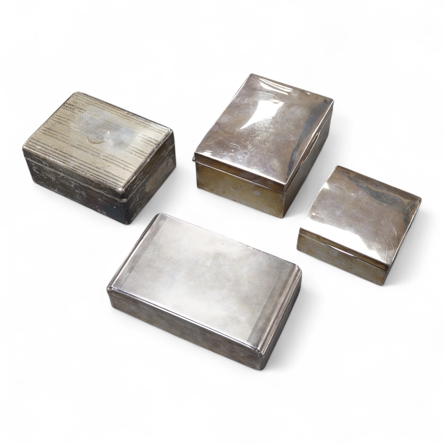 Four assorted silver mounted cigarette boxes, the largest by William Neale & Son Ltd, Birmingham, 1952, 14cm.